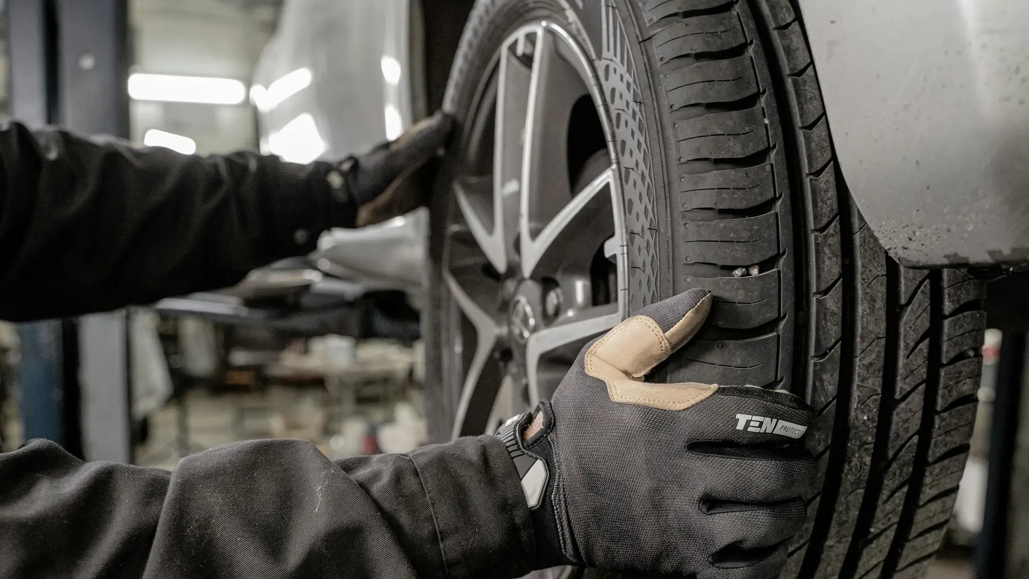 Mecánico con guantes revisando una llanta en un taller