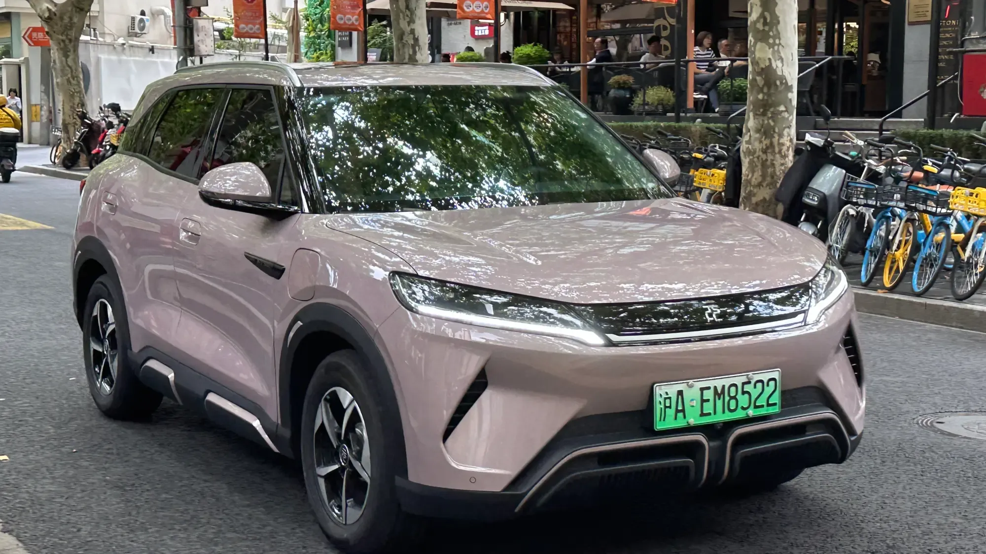 BYD Yuan Up de color rosa pálido visto de frente y de lado en una calle